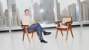 A minimal studio interview setup with two chairs facing each other under soft lighting