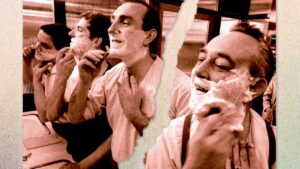7 Grooming Rules Worth Breaking Man examining his face in a bathroom mirror during a morning grooming routine