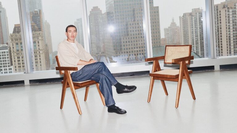 A minimal studio interview setup with two chairs facing each other under soft lighting
