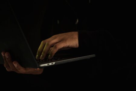 Apple Tightens macOS Disk Access After A person adjusting privacy and security settings on a laptop computer