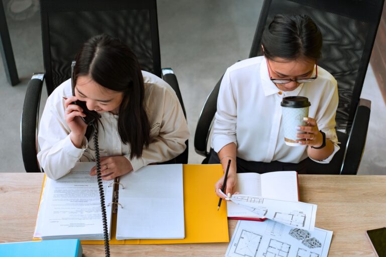 Microsoft Opens Voluntary Exit Door to 60,000 Employees Employees working at desks in a large open-plan corporate office