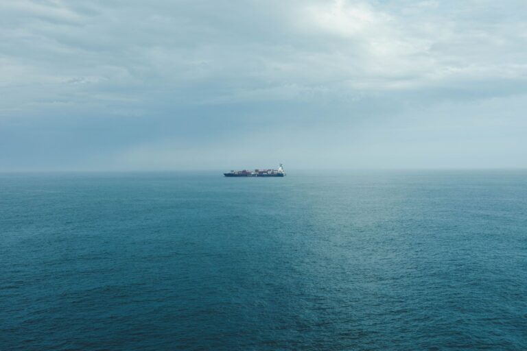 Large cargo ship sailing across open ocean waters