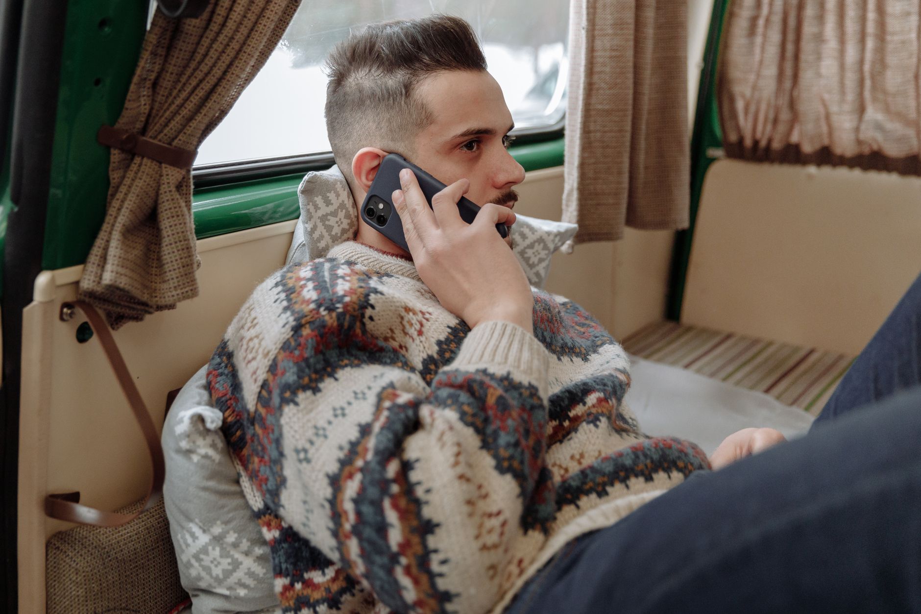 Person making a phone call indoors, engaged in direct personal conversation