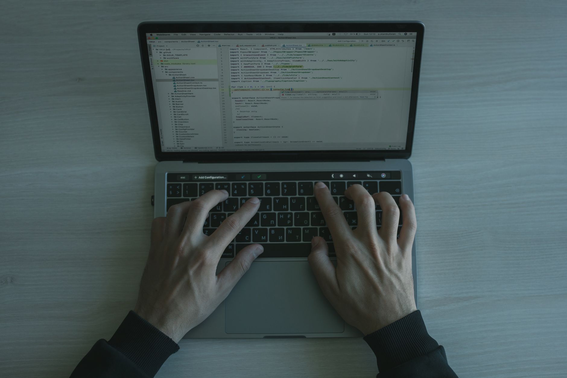Developer reviewing code on a laptop screen in a dark office
