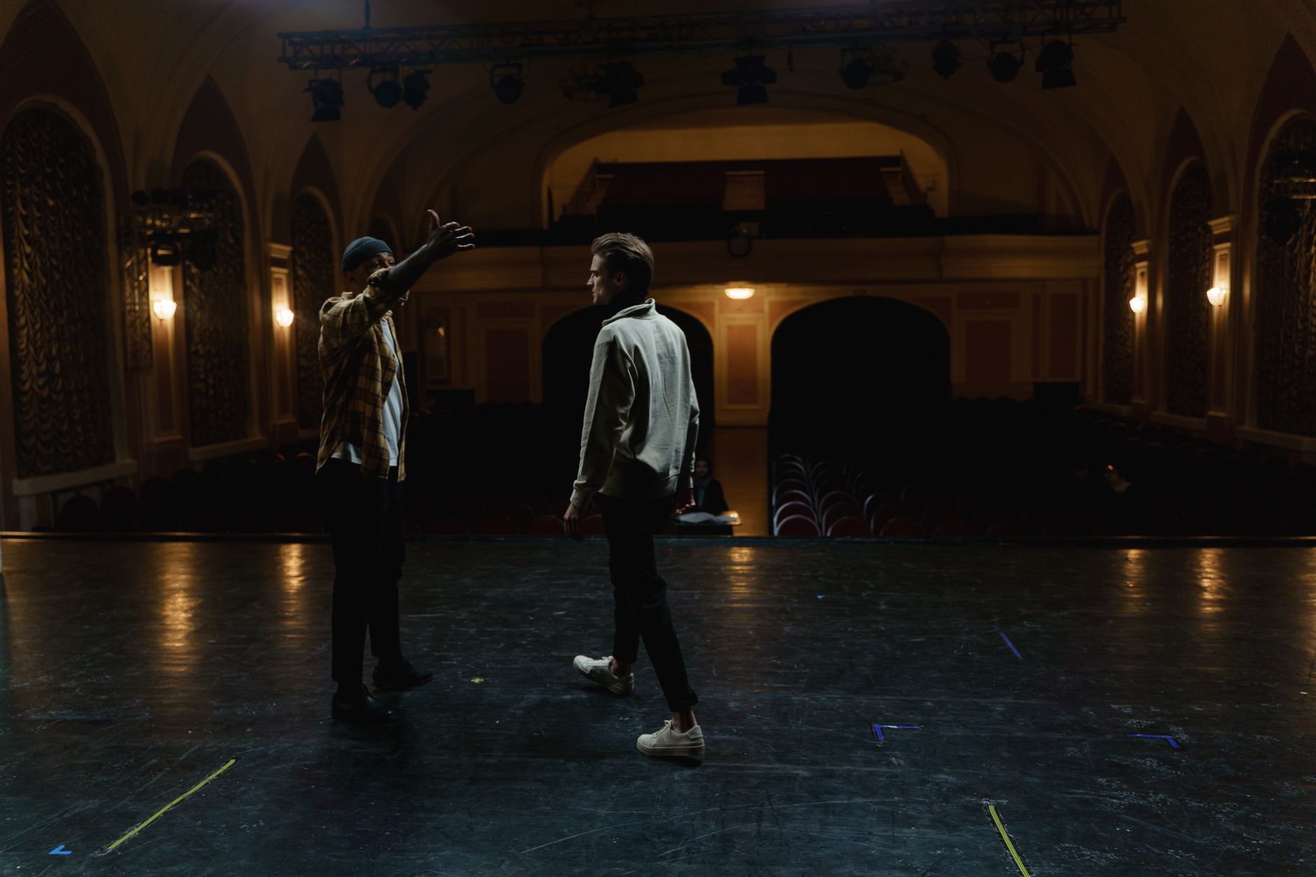 Two actors in rehearsal, facing each other in a tense dramatic moment
