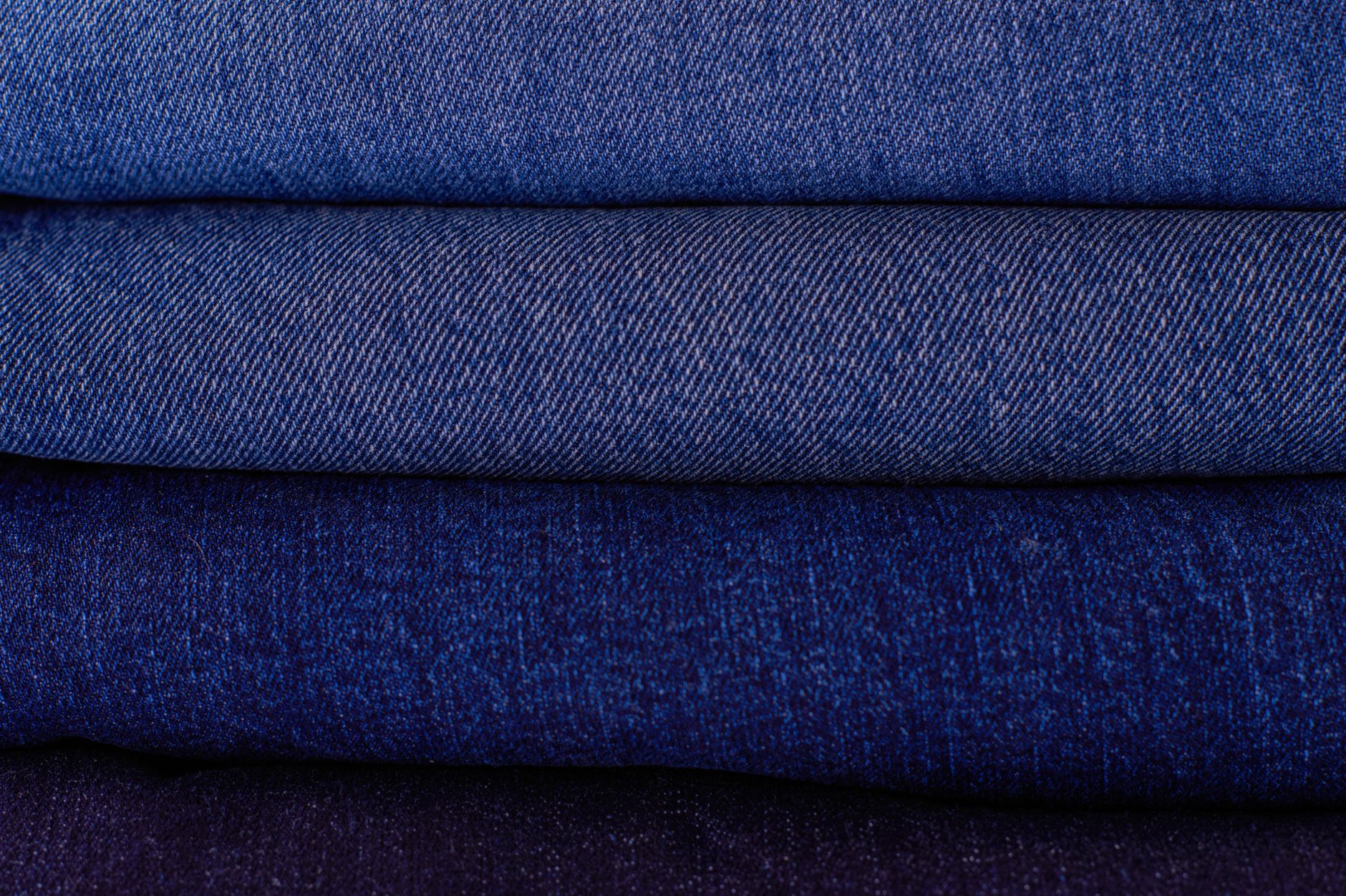 Stacked raw denim jeans showing deep indigo color and fabric weight
