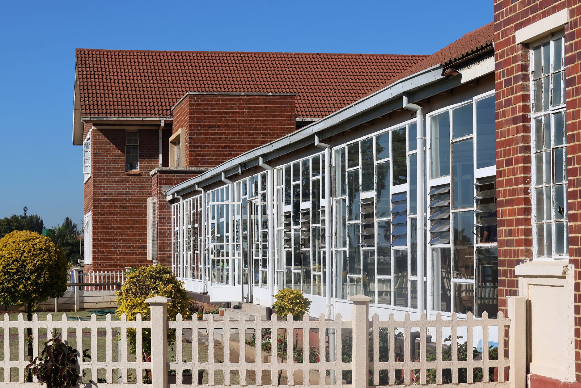 Exterior of a public school building with an empty sidewalk in front