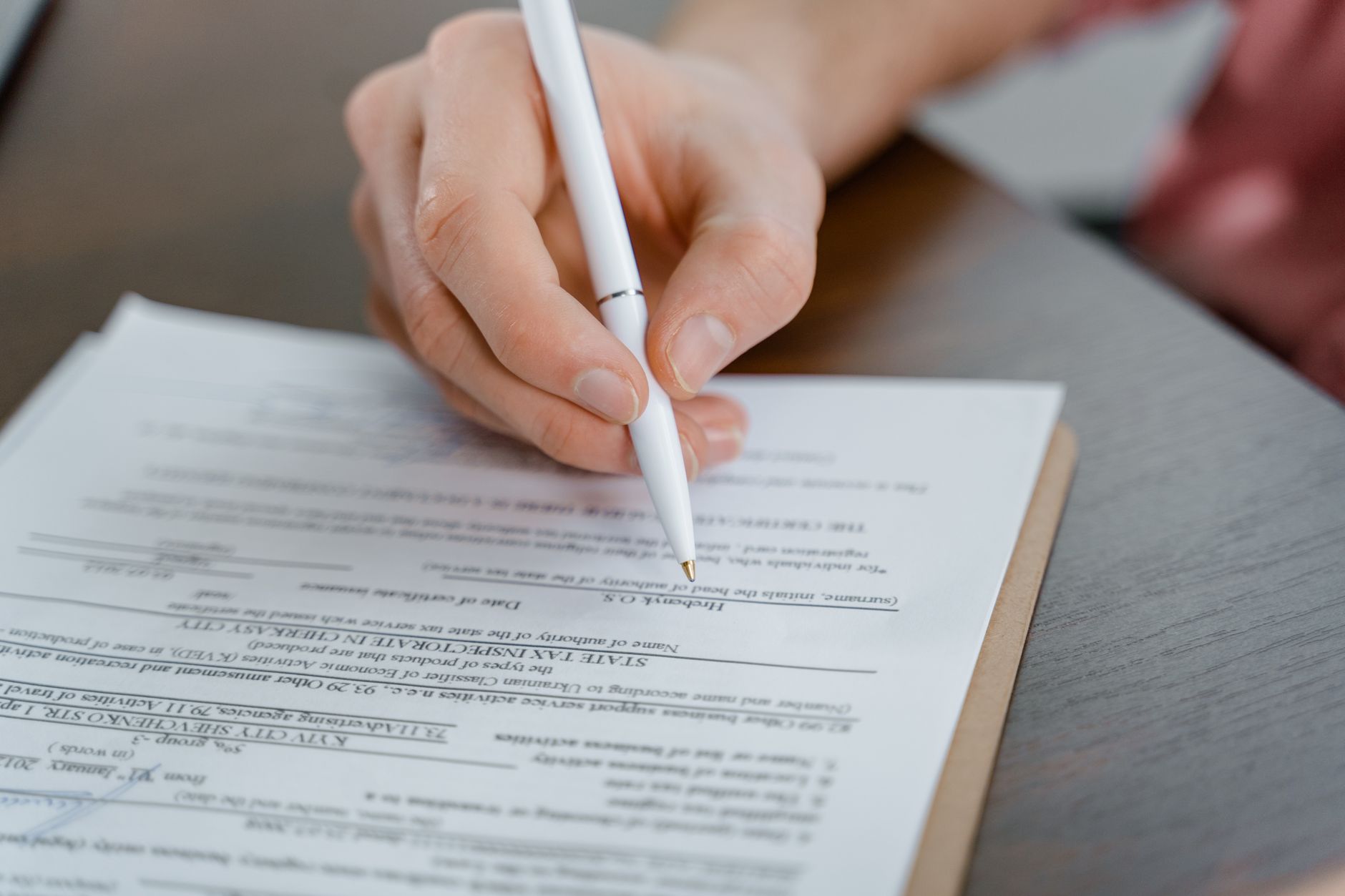 Close-up of official legal documents on a desk with a pen beside them
