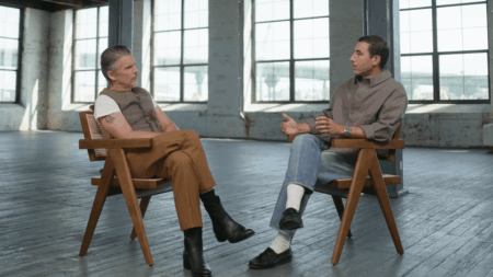 A man being interviewed in a softly lit studio setting